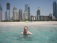 Anders bader i den Persiske Golf med Dubai Marina i baggrunden