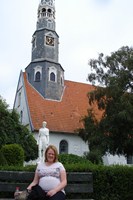 Højgravid Monica foran kirken i Heide